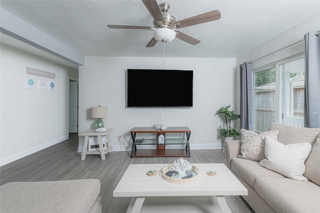 living room with ceiling fan, baseboards, dark wood finished floors, and a textured ceiling