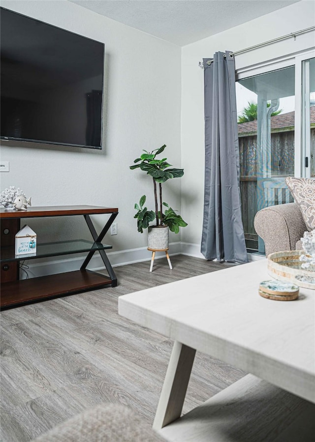 sitting room with baseboards and wood finished floors