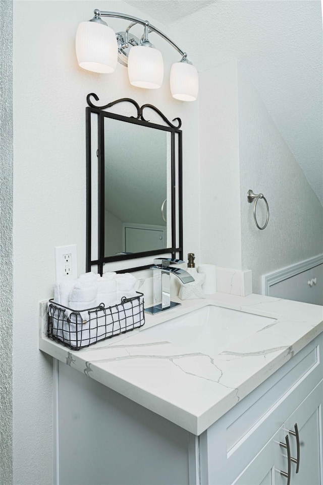 bathroom featuring a textured wall and vanity