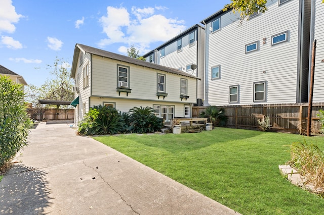 rear view of property with a yard and fence