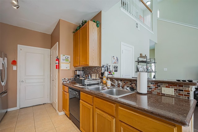 kitchen with light tile patterned floors, visible vents, a sink, dishwasher, and a peninsula