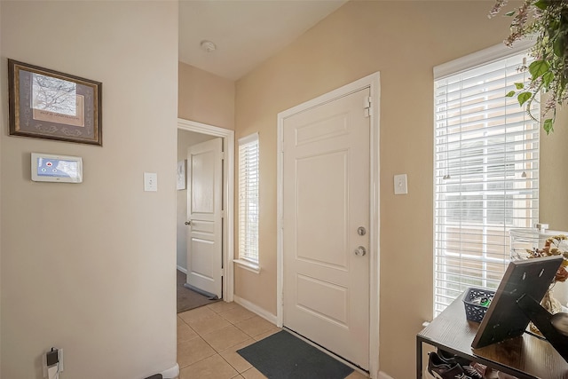 entryway featuring a wealth of natural light, baseboards, and light tile patterned floors