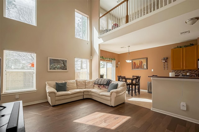 living area featuring wood finished floors, visible vents, and baseboards