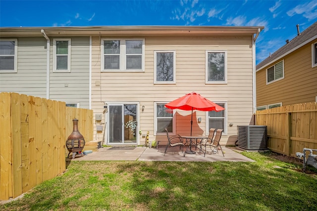 rear view of house with a fenced backyard, a yard, a patio, and central air condition unit