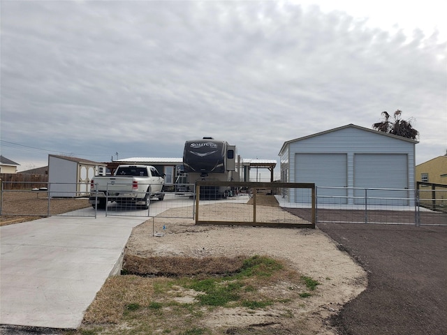 view of yard with a garage, an outbuilding, and fence