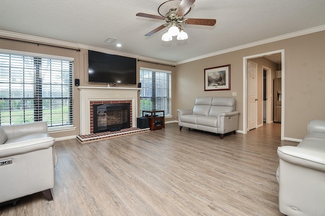 unfurnished living room featuring a fireplace, crown molding, light wood-style flooring, and a textured ceiling