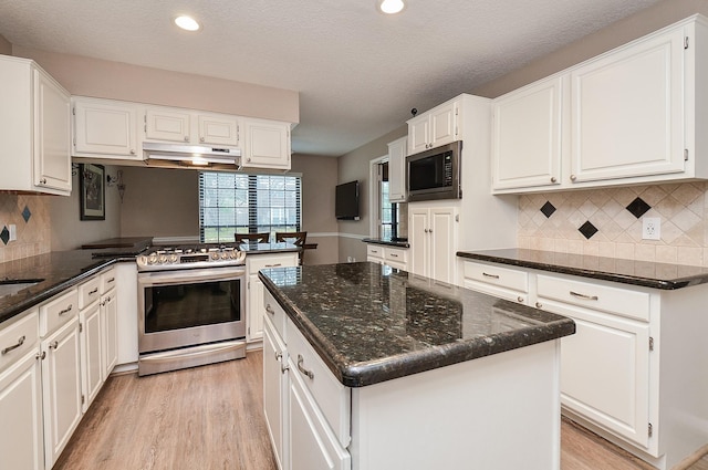 kitchen with appliances with stainless steel finishes, a center island, and white cabinetry