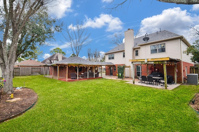 rear view of property featuring central AC unit, a patio, a fenced backyard, a yard, and brick siding