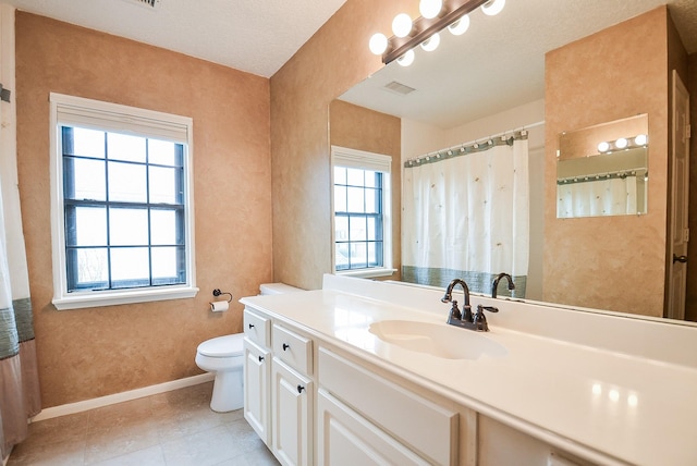 bathroom with visible vents, toilet, vanity, baseboards, and tile patterned floors