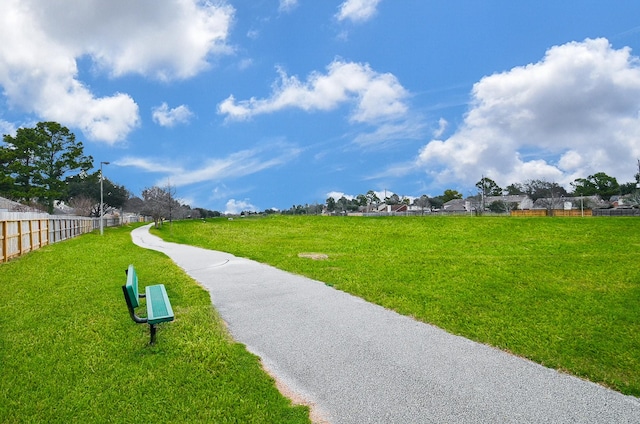 view of home's community with a yard and fence