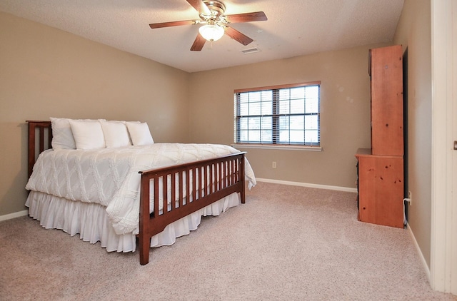 bedroom with ceiling fan, a textured ceiling, light colored carpet, visible vents, and baseboards