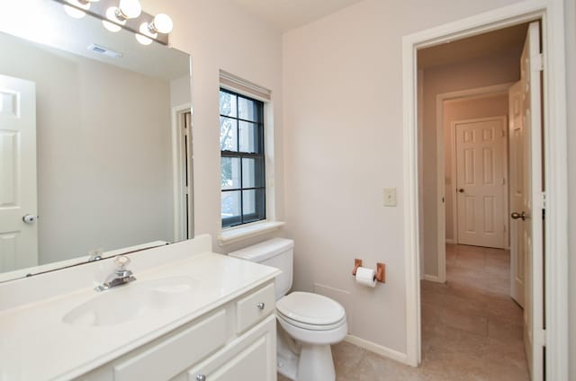 bathroom featuring visible vents, baseboards, toilet, tile patterned floors, and vanity