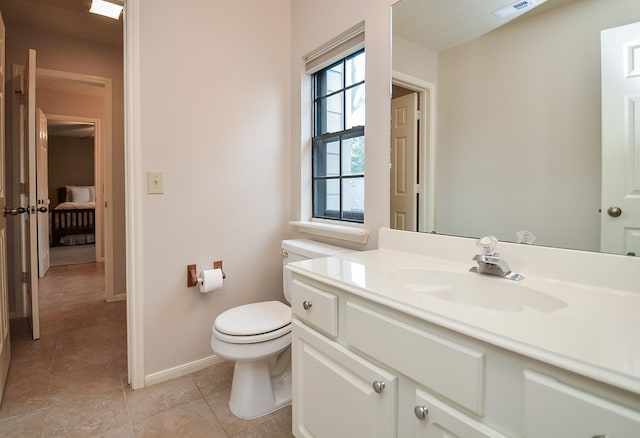 bathroom featuring toilet, vanity, baseboards, visible vents, and tile patterned floors