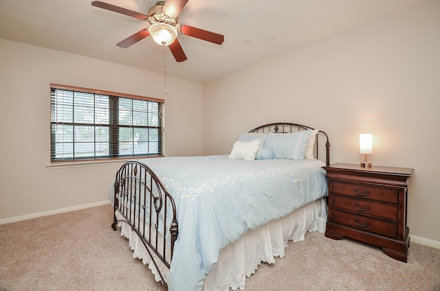 bedroom with light colored carpet, ceiling fan, and baseboards