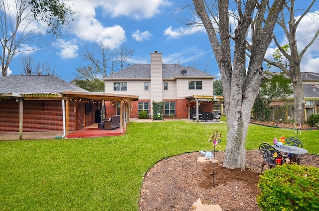 rear view of house featuring a chimney, fence, a lawn, and a patio