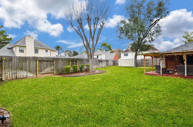 view of yard with a fenced backyard, a shed, an outbuilding, and a patio