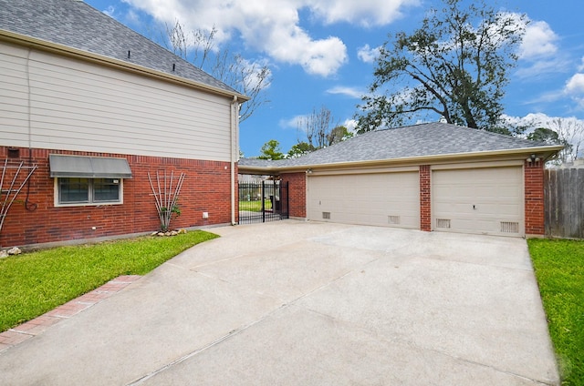 view of side of property with driveway, brick siding, a shingled roof, and fence