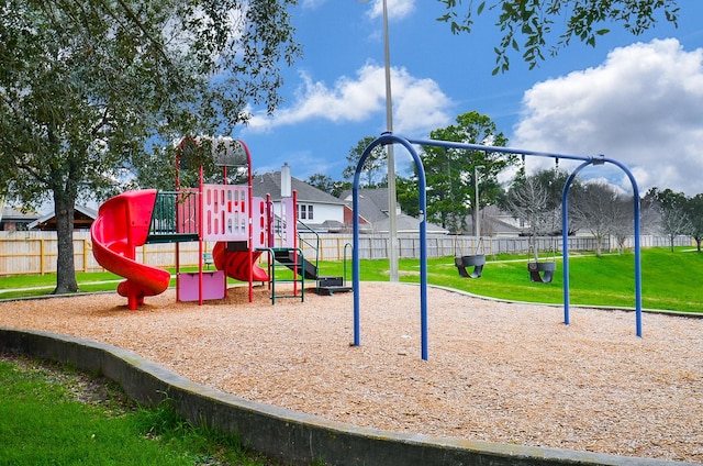 community jungle gym with a yard and fence