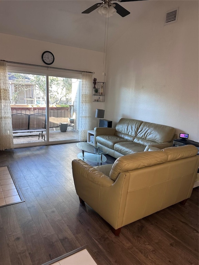 living area with lofted ceiling, ceiling fan, visible vents, and dark wood finished floors