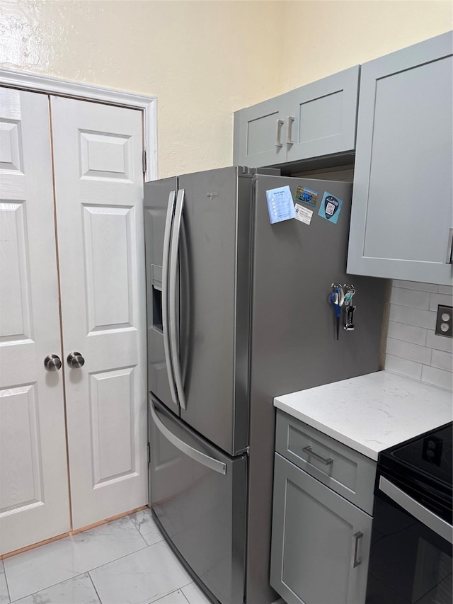 kitchen with gray cabinets, backsplash, and marble finish floor