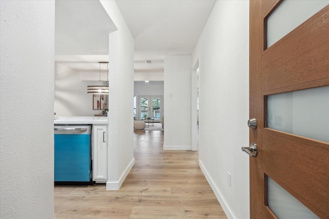 corridor with visible vents, light wood-style flooring, and baseboards