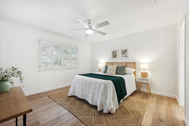 bedroom with a ceiling fan, light wood-style flooring, and baseboards