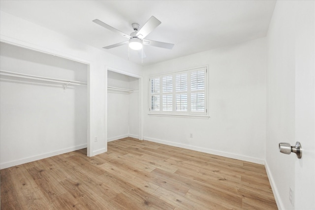 unfurnished bedroom featuring multiple closets, baseboards, ceiling fan, and light wood finished floors