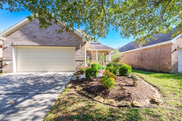 view of front facade featuring driveway, brick siding, an attached garage, and fence