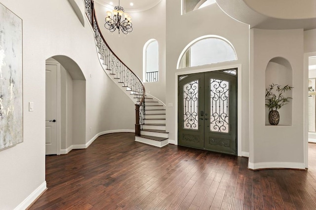 entryway featuring a chandelier, dark wood-style flooring, baseboards, stairs, and french doors