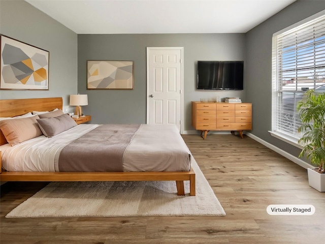 bedroom featuring baseboards and wood finished floors