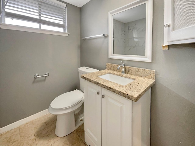 bathroom featuring toilet, tile patterned flooring, baseboards, and vanity