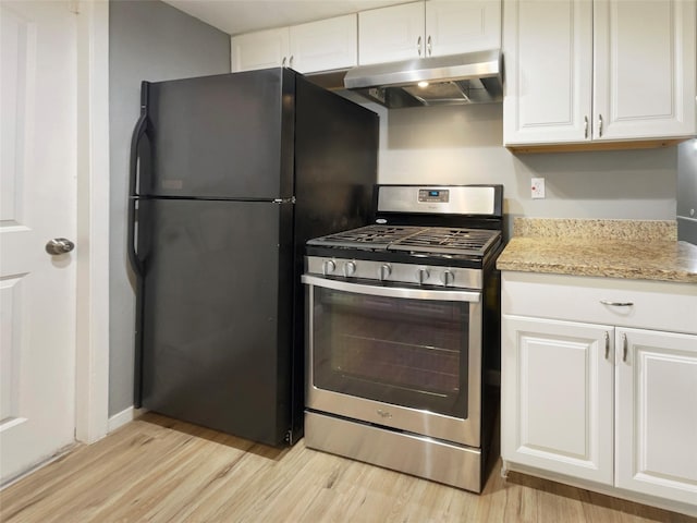 kitchen featuring stainless steel gas stove, freestanding refrigerator, white cabinetry, and under cabinet range hood