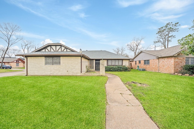 view of front of home with a front lawn and brick siding