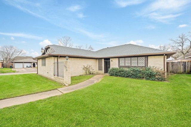 single story home featuring brick siding, roof with shingles, a front yard, and fence