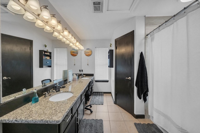 bathroom with double vanity, a sink, visible vents, and tile patterned floors