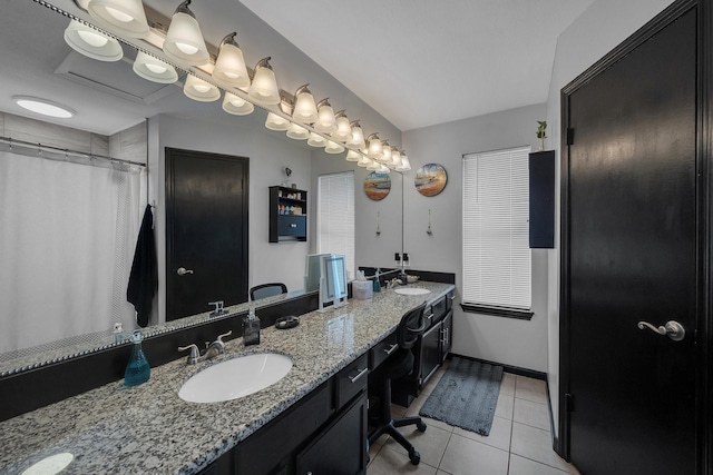 full bathroom featuring baseboards, double vanity, a sink, and tile patterned floors