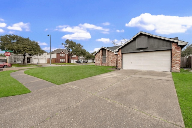 view of front of home with a garage, brick siding, driveway, a residential view, and a front lawn