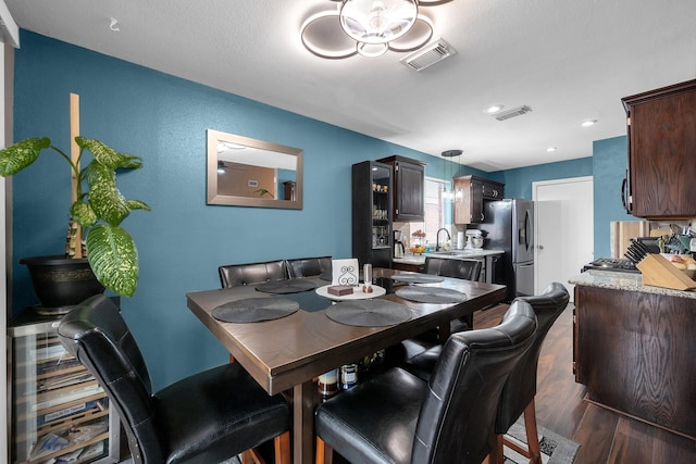 dining area featuring dark wood-type flooring and visible vents