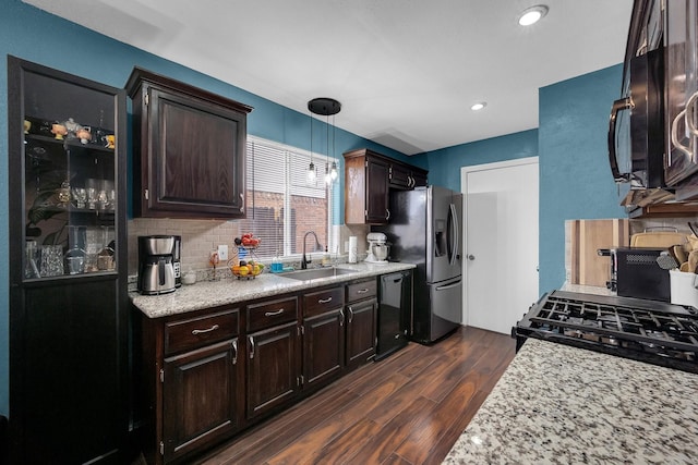 kitchen with dishwasher, stainless steel fridge with ice dispenser, dark wood-type flooring, pendant lighting, and a sink