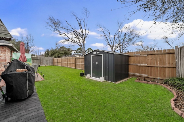 view of yard featuring an outbuilding, a fenced backyard, and a storage shed