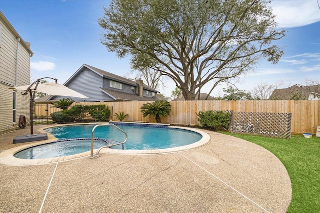 view of pool featuring a fenced backyard, a pool with connected hot tub, and a patio