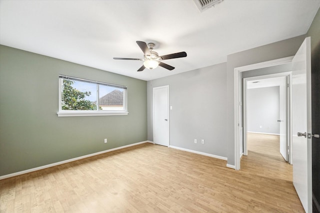 unfurnished bedroom with light wood finished floors, a ceiling fan, visible vents, and baseboards