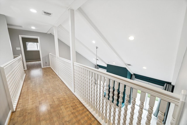 hall with visible vents, lofted ceiling with beams, and wood finished floors