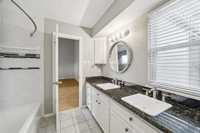 full bathroom with double vanity, a sink, baseboards, and tile patterned floors