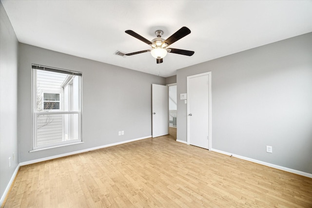 spare room with visible vents, light wood-style flooring, and baseboards