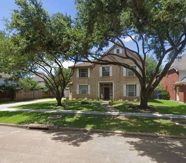 view of front of house with fence and a front lawn