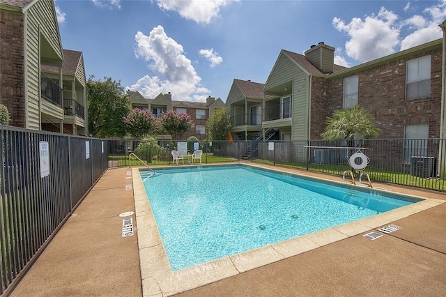 community pool featuring a residential view and fence