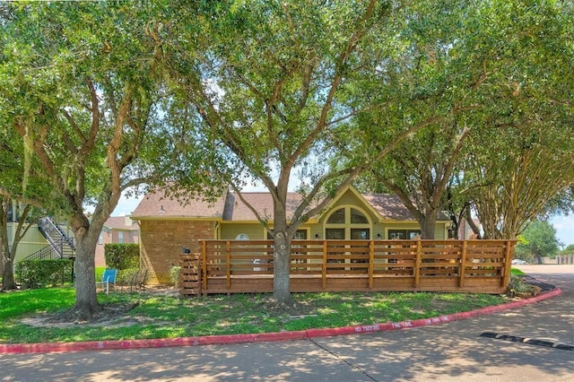 view of front of home featuring brick siding and a deck