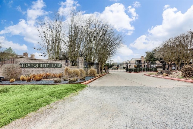 exterior space with a residential view, a gate, a gated entry, and curbs