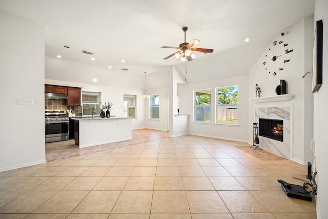 unfurnished living room featuring a ceiling fan, a high end fireplace, light tile patterned flooring, vaulted ceiling, and baseboards